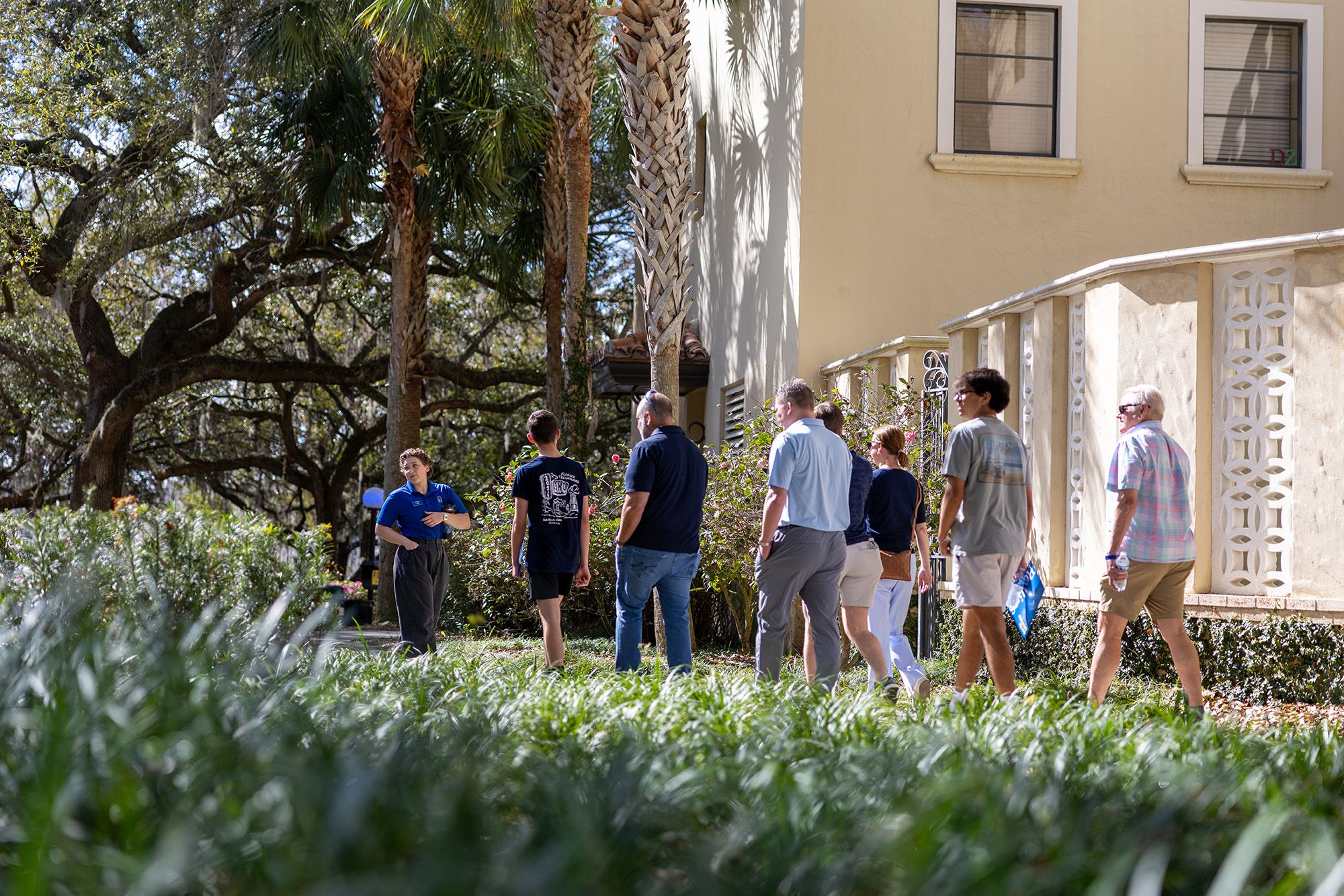 A student leads a small group of prospective students and parents on a tour of Rollins College.