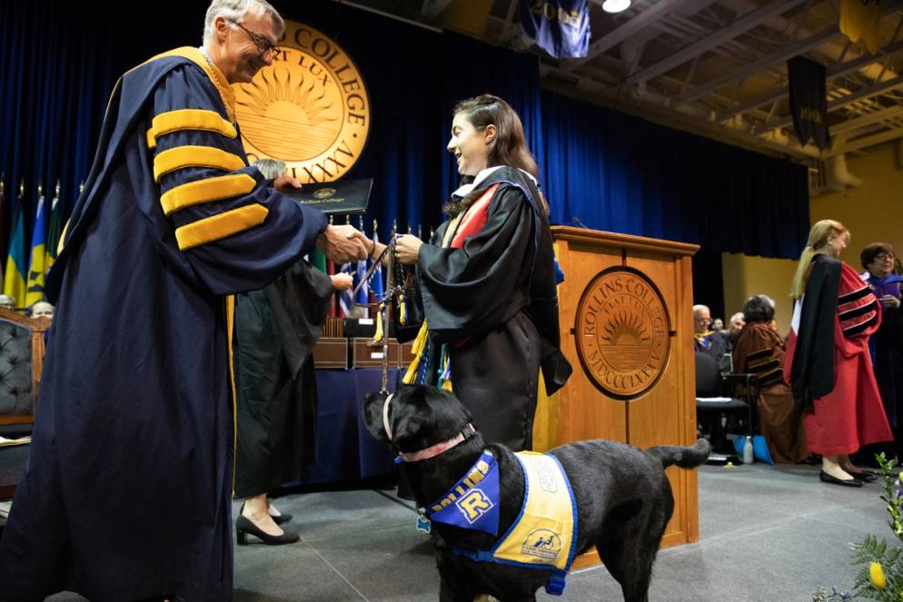 President Cornwell greets a student and a guide dog.