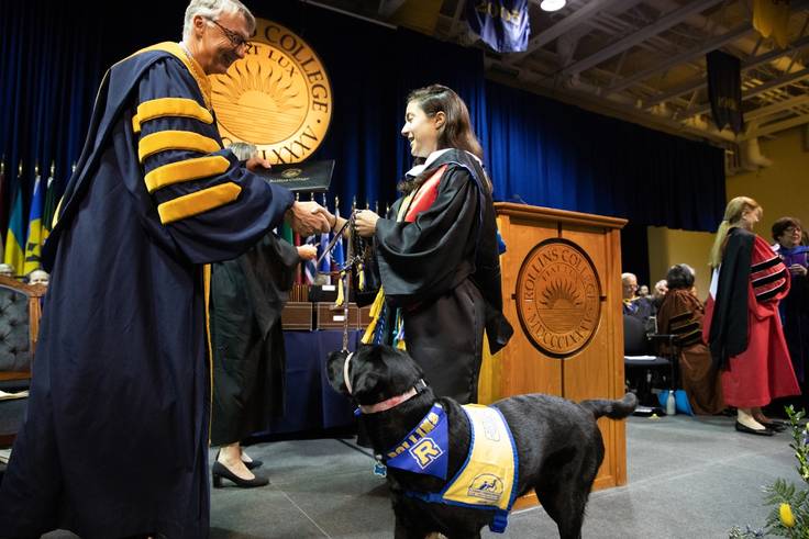 President Cornwell greets a student and a guide dog.