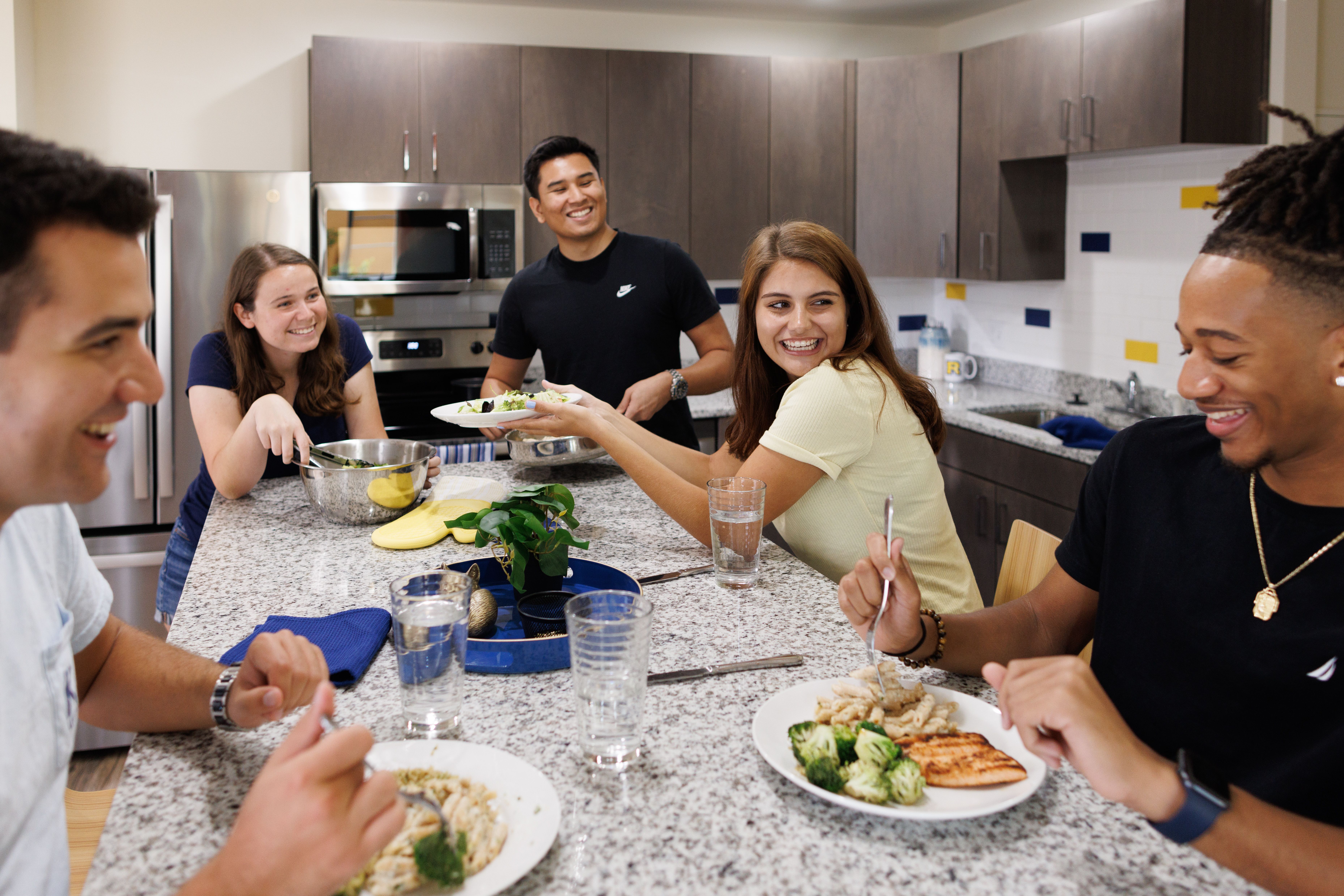 A resident assistant holds a sign that reads ask me for help.