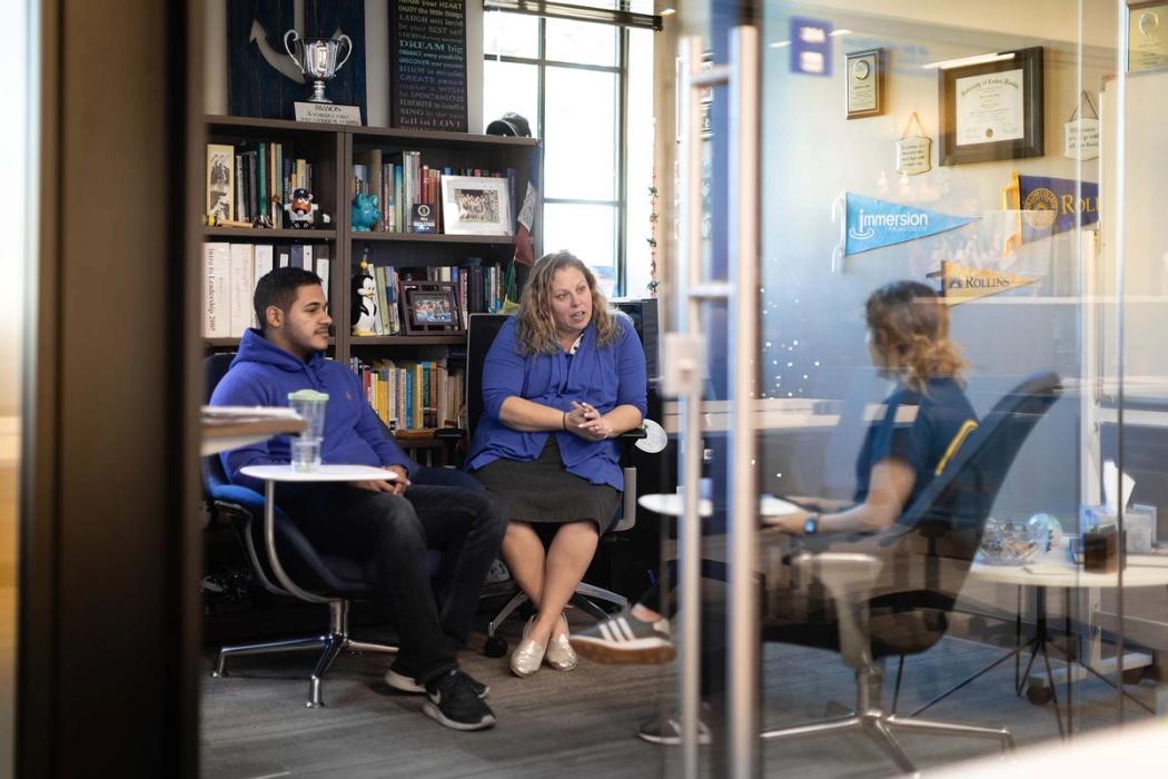 A college advisor meets with two students in her office.