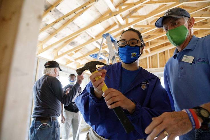 A student holds a hammer at Habitat for Humanity