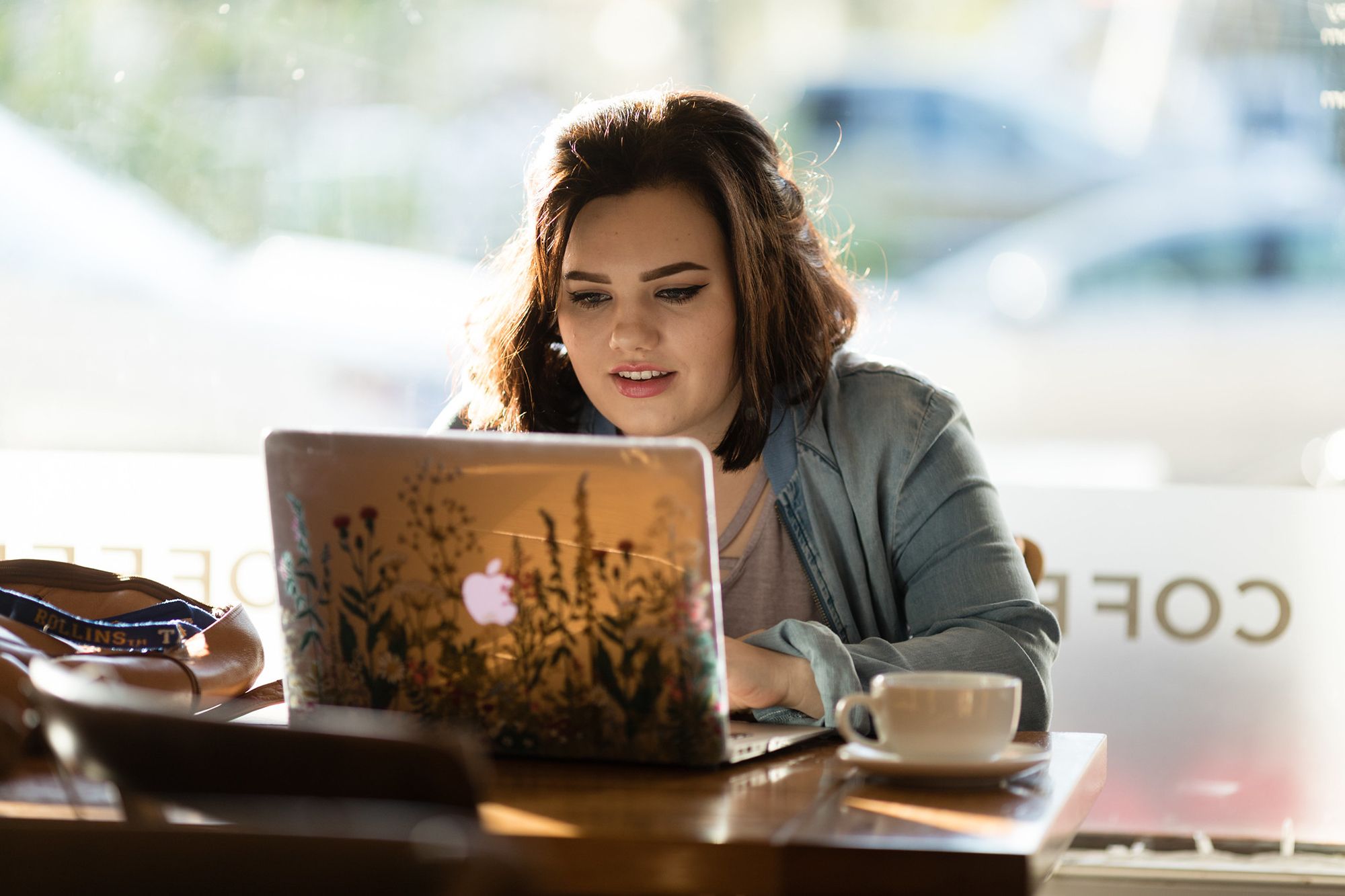 A student video chats in a coffee shop.