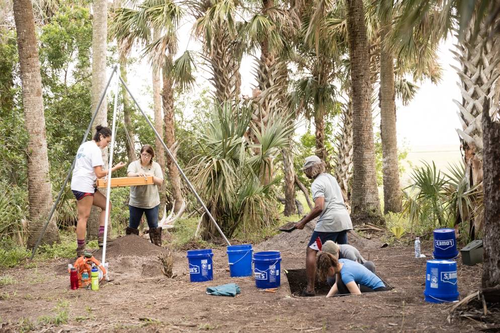 Students working together on the archaeological dig site.