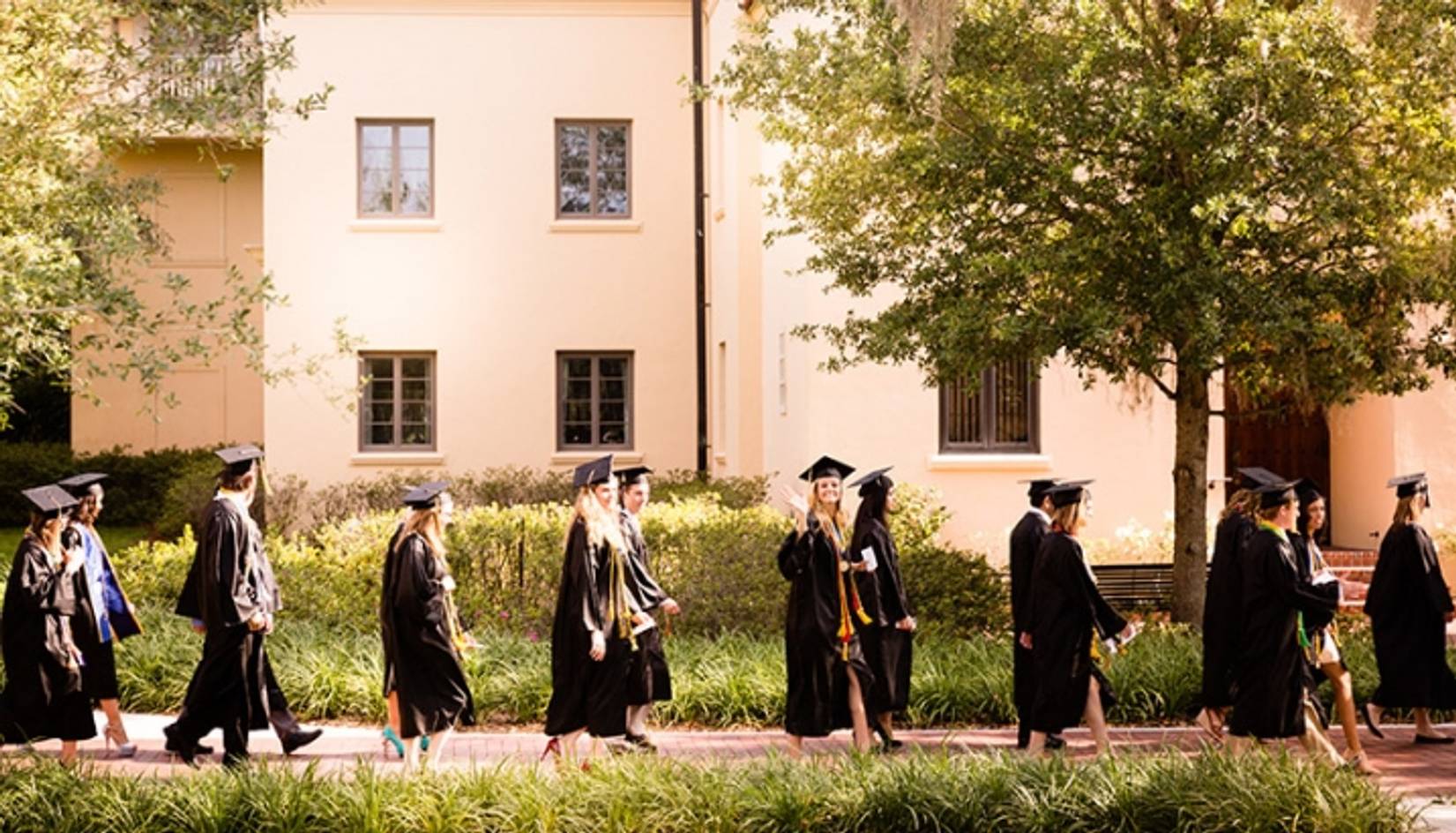 Rollins students walking toward their commencement ceremony.