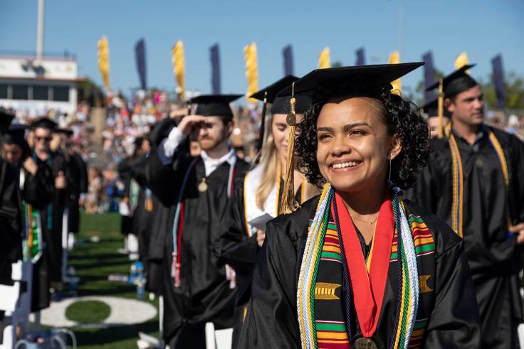 A students smiles during a commencement ceremony.