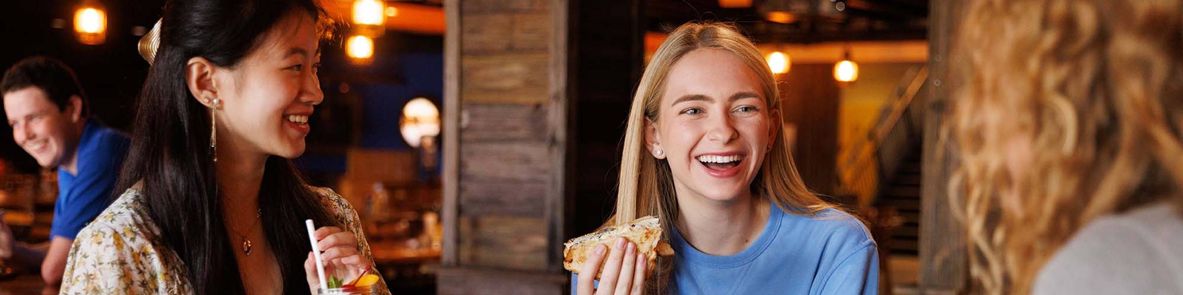 A group of Rollins College students eating in a campus dining hall.