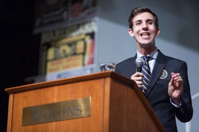 A debate team student speaking from the podium in the Annie Russell Theatre.
