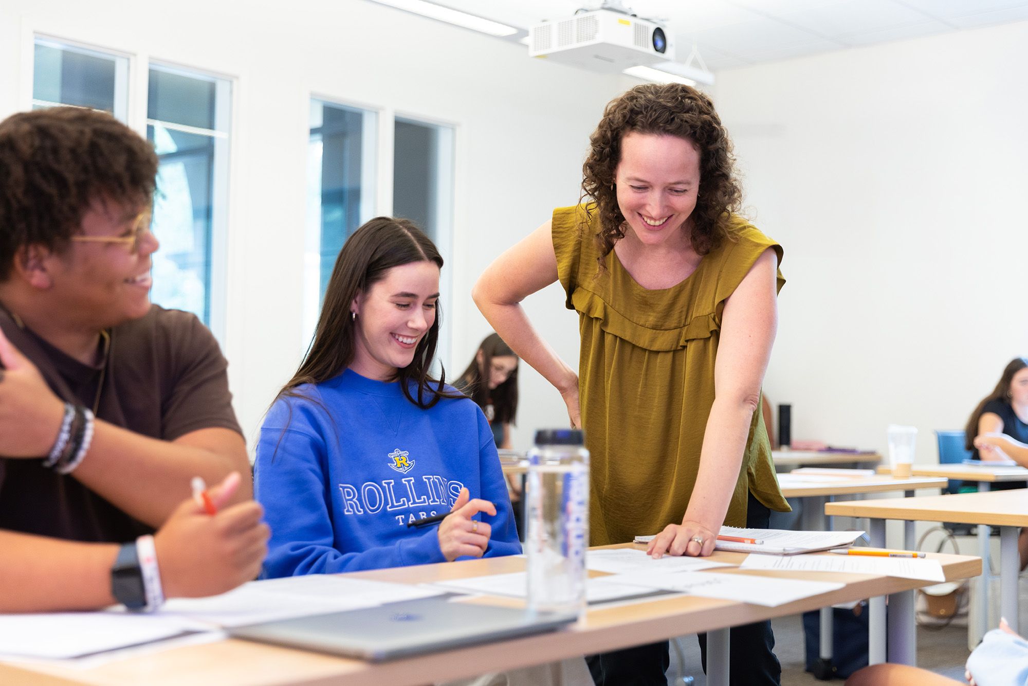A professor works with two students during a psychology class.