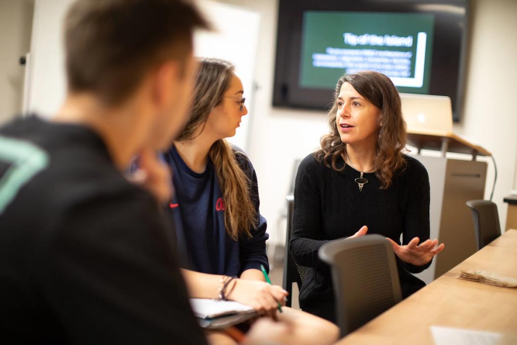 Rollins students speak to a professor about a class project.