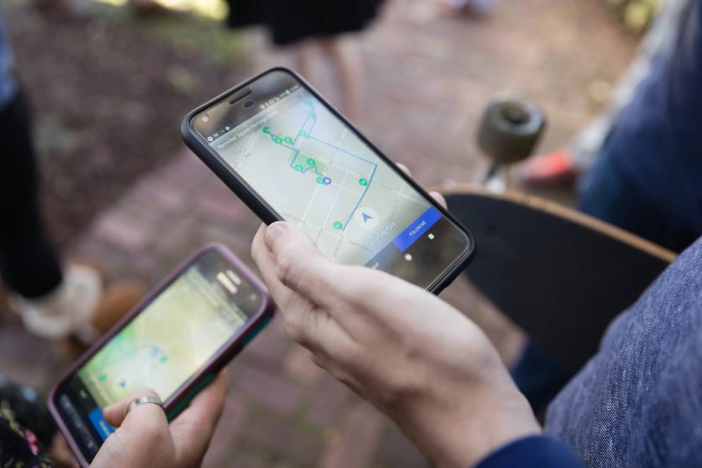 Close up of college students looking at their phone screens with walking directions and waypoints.