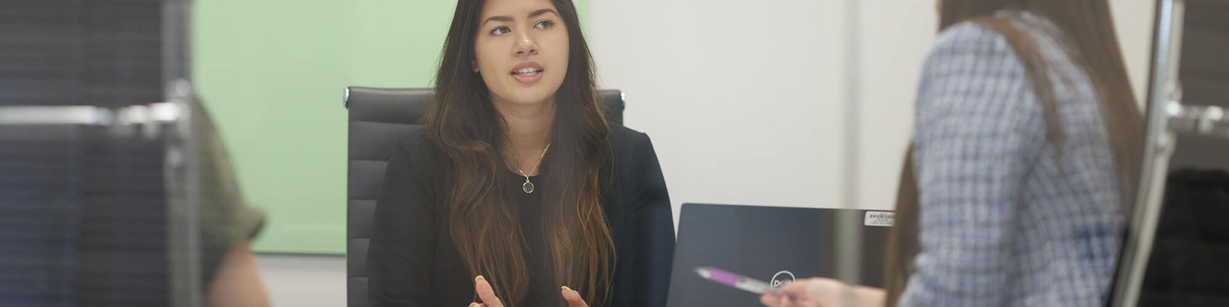 A business advisor works with two students.