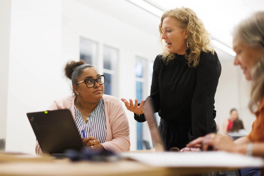 An education professor works one on one with a student.