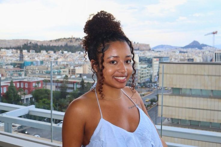Jayla Cargill ’27 smiling on rooftop terrace overlooking a sprawling cityscape at sunset.