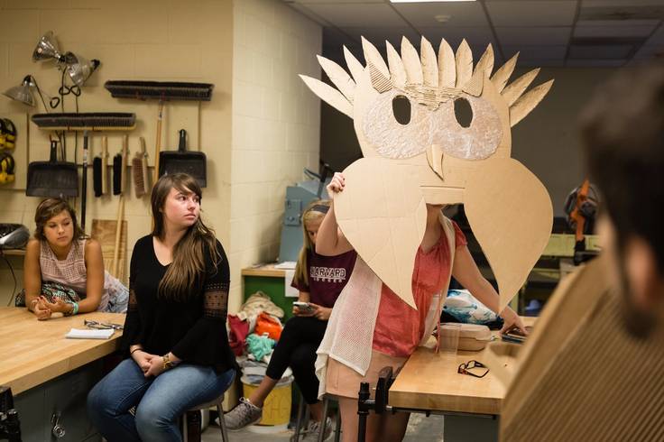 A student wearing an owl mask.