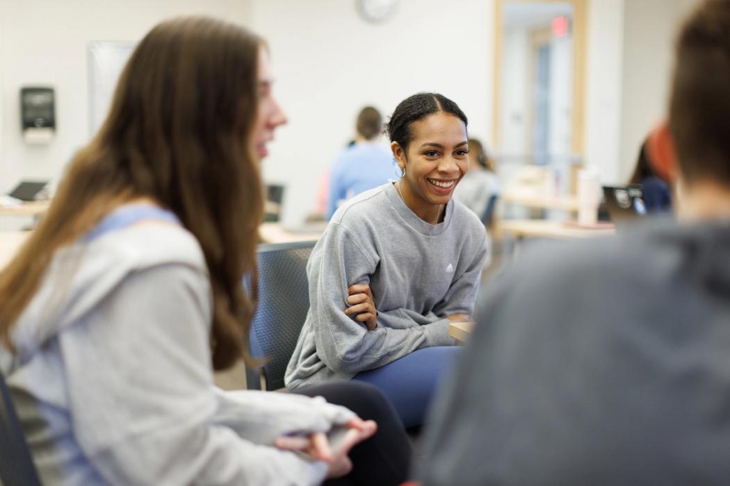 A student smiles at a classmate during a small-group classroom project.