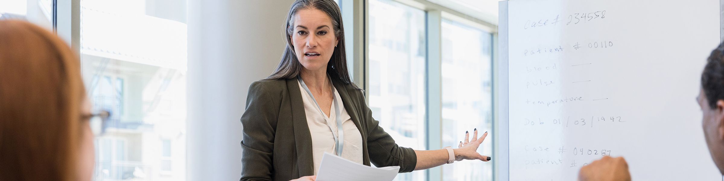 A female hospital administrator leads a meeting.