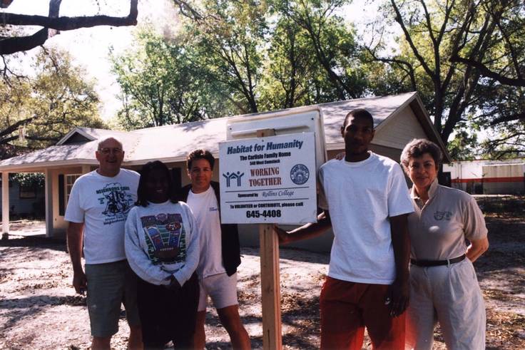 Thaddeus and Polly Seymour pose in front of a Habitat for Humanity house with student volunteers