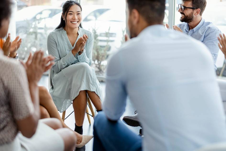 A group of people are meeting and clapping together