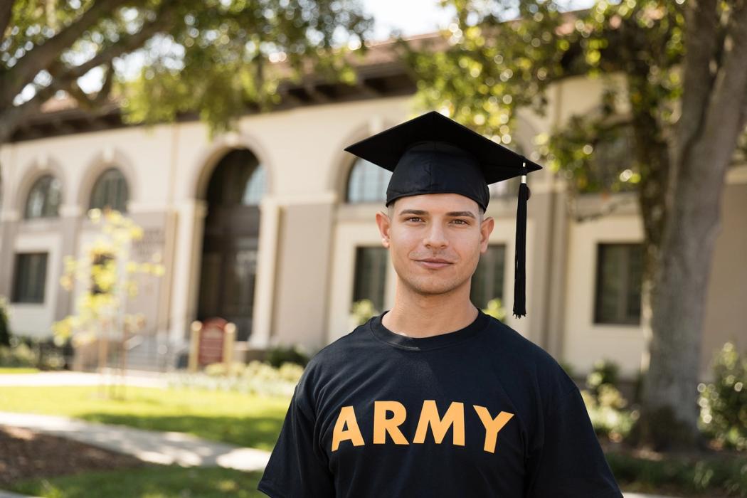 A college student wears an ARMY t-shirt and a commencement cap.