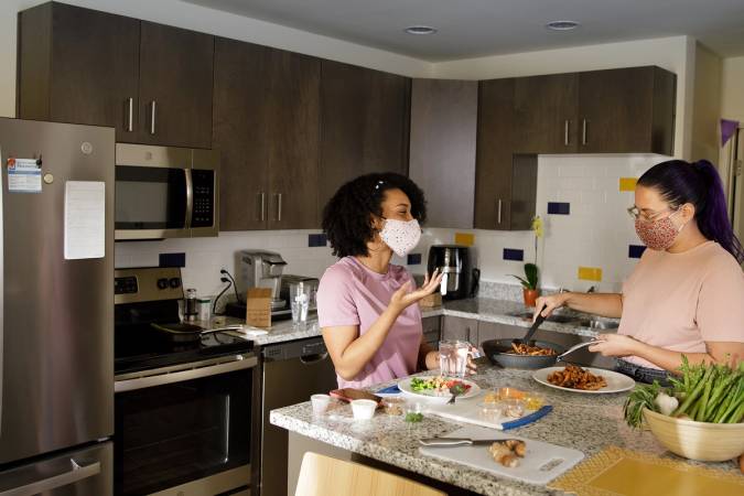 Students cooking dinner in their full-size kitchen in Lakeside Neighborhood.