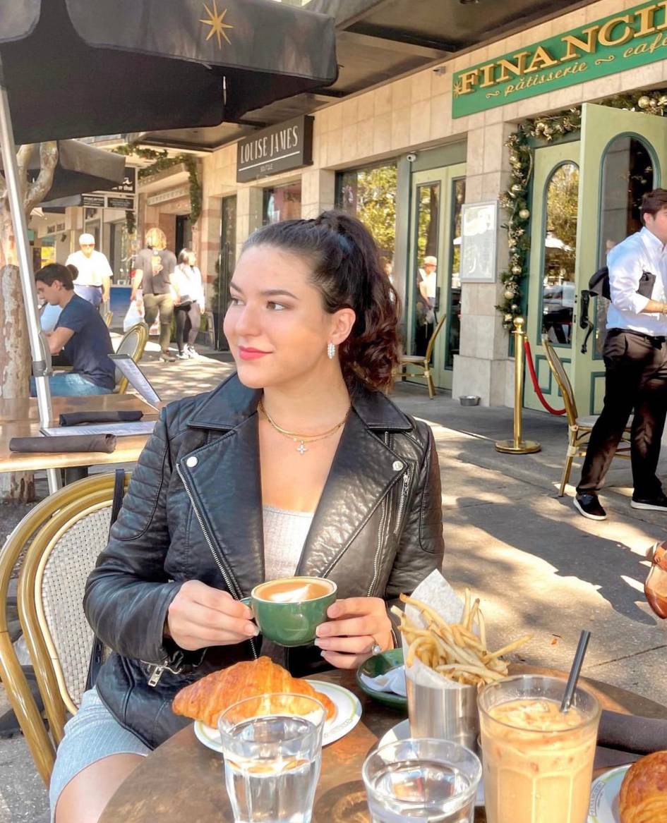 Rollins student drinking coffee on Park Avenue.