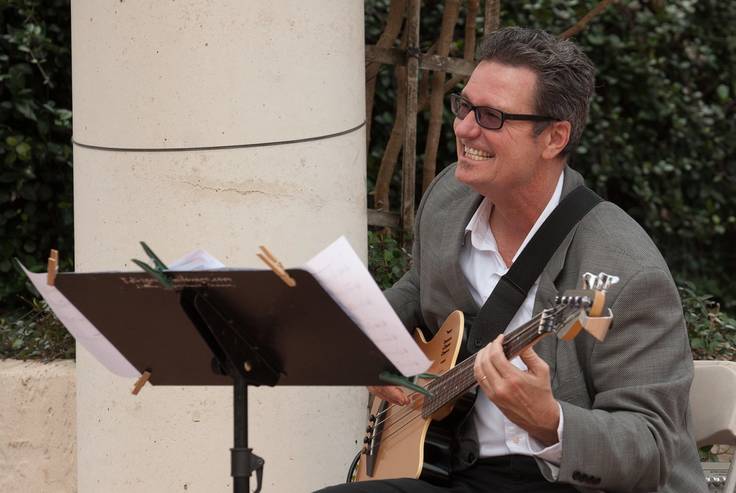 Music professor plays guitar for a concert on campus.