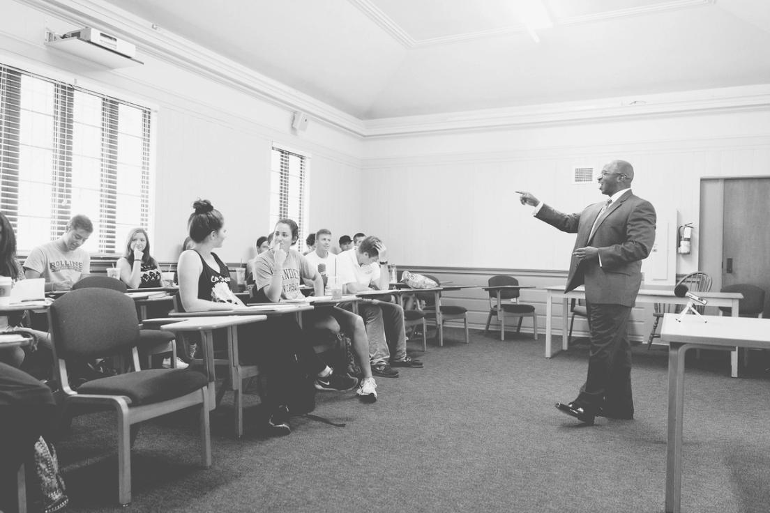 Professor Eric Smaw standing in front of his class pointing to a student.