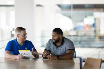 An admission counselor meets one on one with a prospective student.