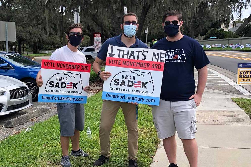 Omar Sadek and fellow classmates promoting his bid for city commission with campaign signs.