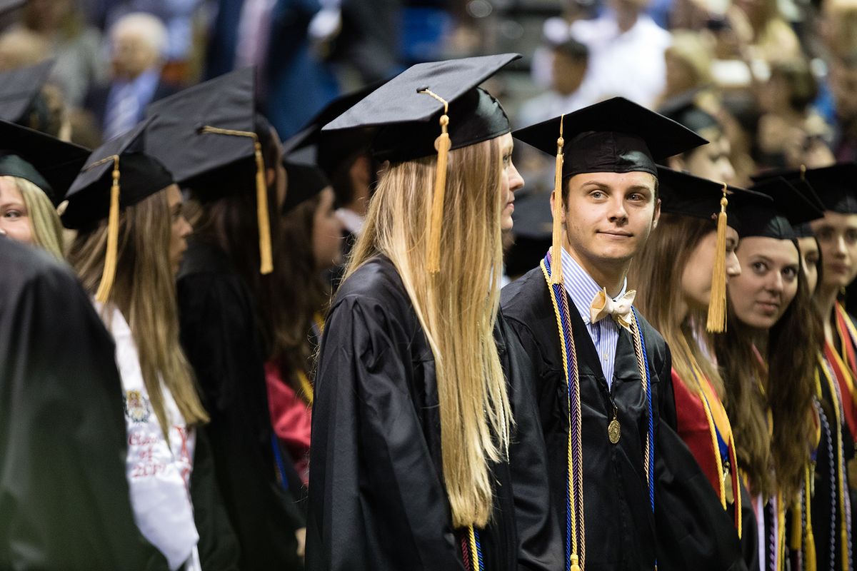 A student smiles at the crowd during a commencement ceremony at Rollins College.