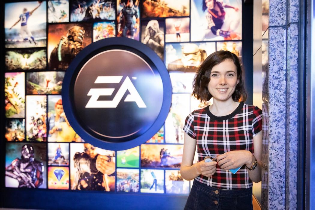 A software engineer poses in front of the EA Sports logo at the company's Orlando headquarters.