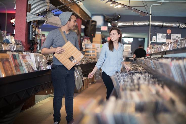 A pair of students explore vinyl at a record shop.