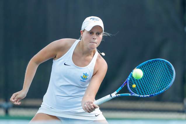A tennis player returning a tennis ball during a game.