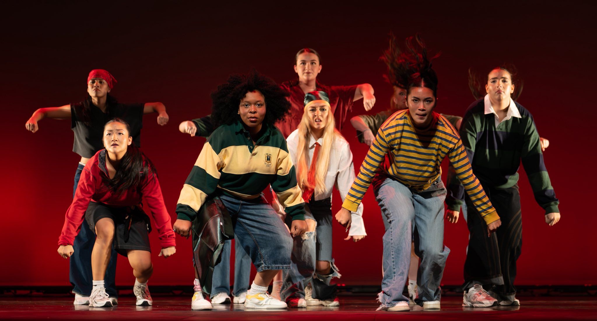 An ensemble of dancers perform a hip-hop piece.