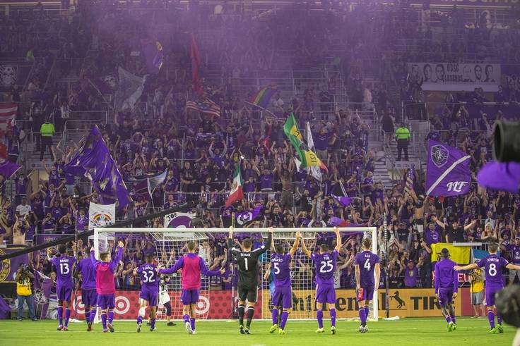 Orlando City players celebrate with supporters after a match.