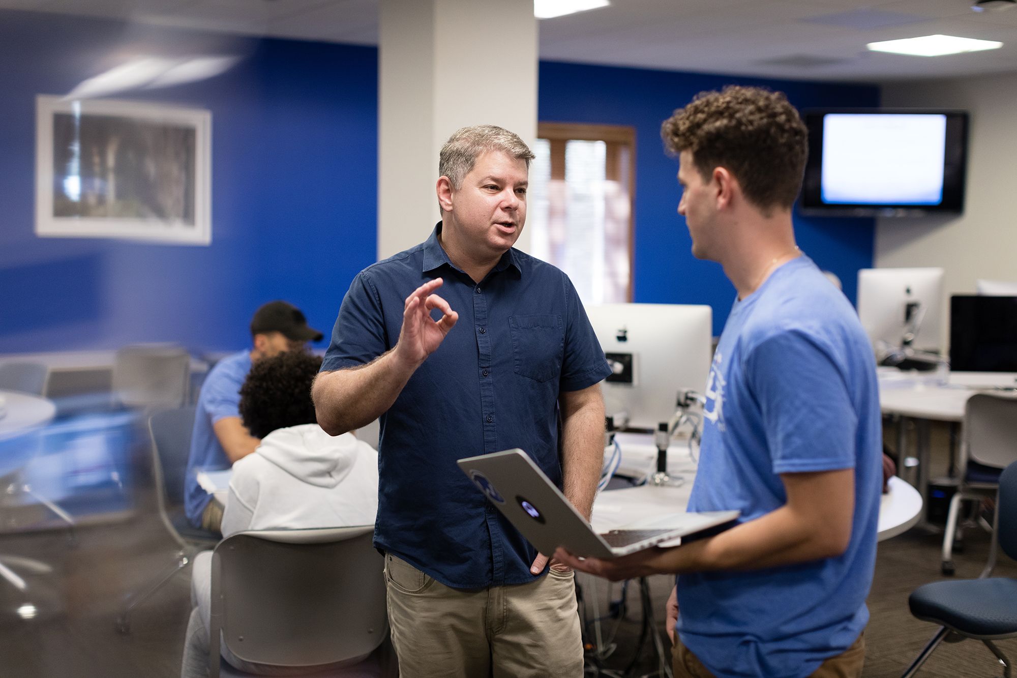 A professor helps a student during a digital storytelling class.