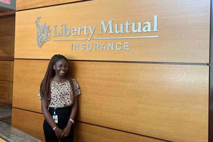 female student standing in front of Liberty Mutual sign
