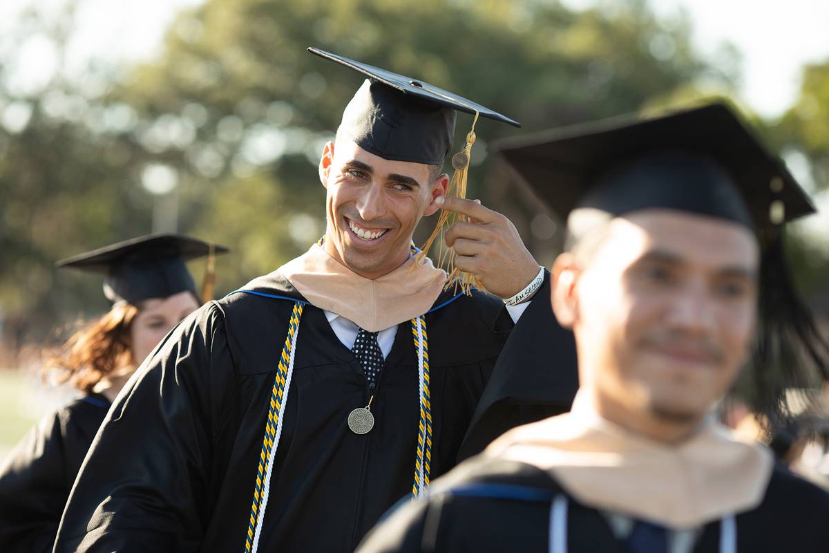 A Rollins college graduate smiles during a commencement ceremony.