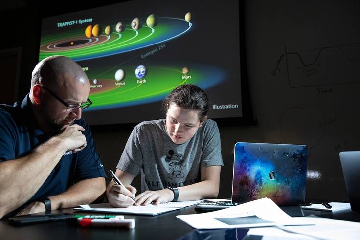 A professor and student conduct physics research.