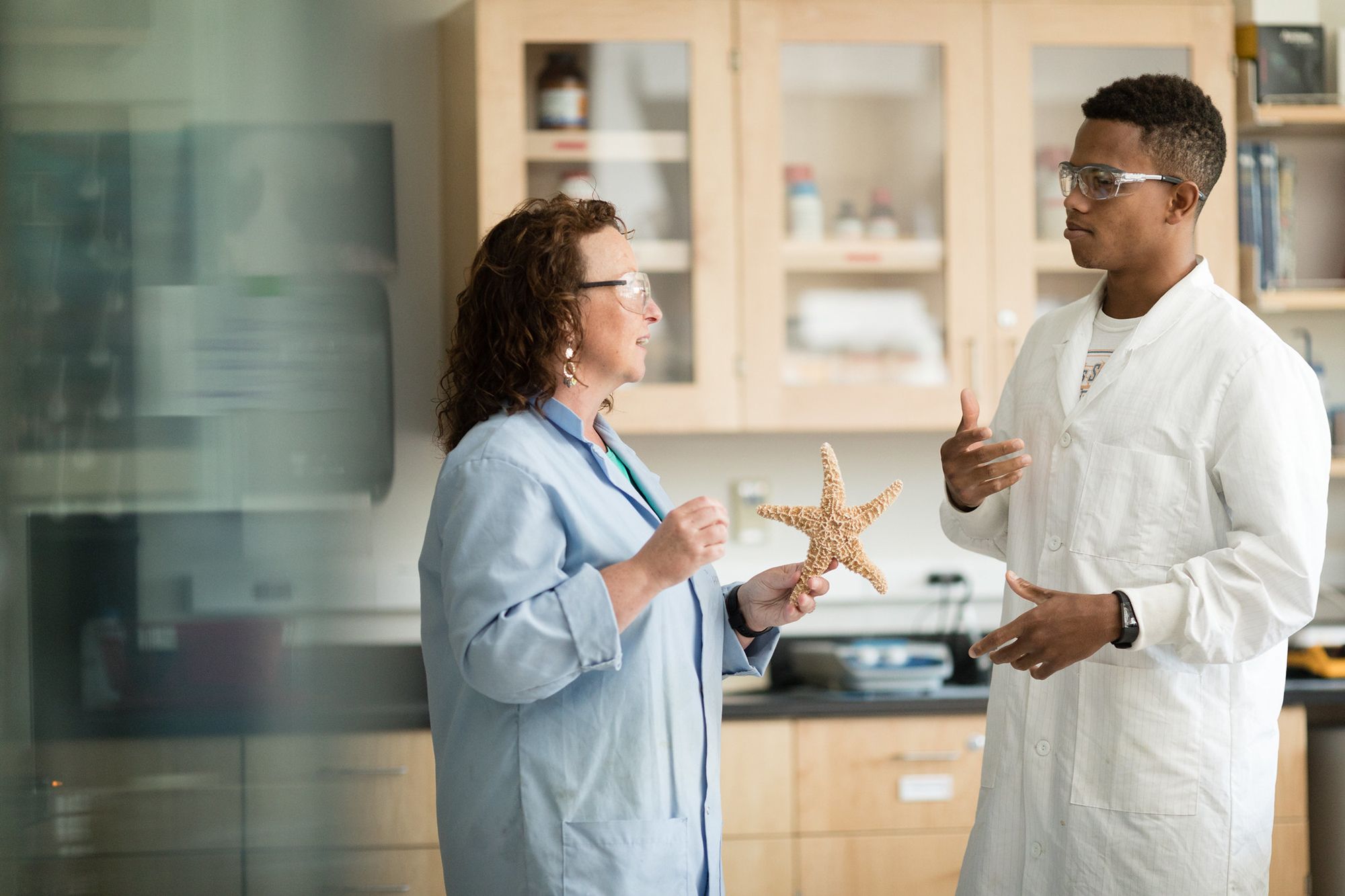 A professor and student examine a starfish.