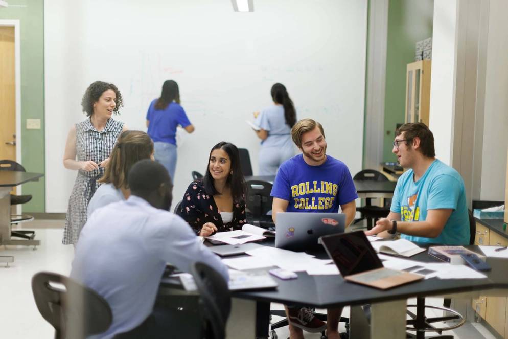 Students gather around a table in the Industrial Mathematics course