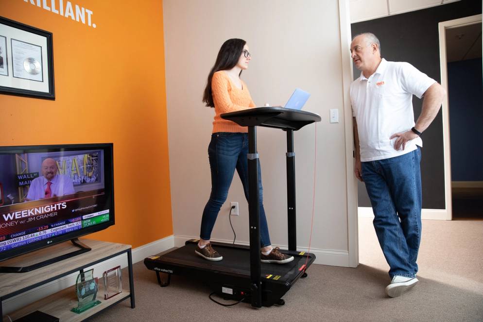 Intern Neny Lairet ’21 discussing the day’s tasks with Knoza Consulting COO Allen Kupetz while walking on the treadmill.