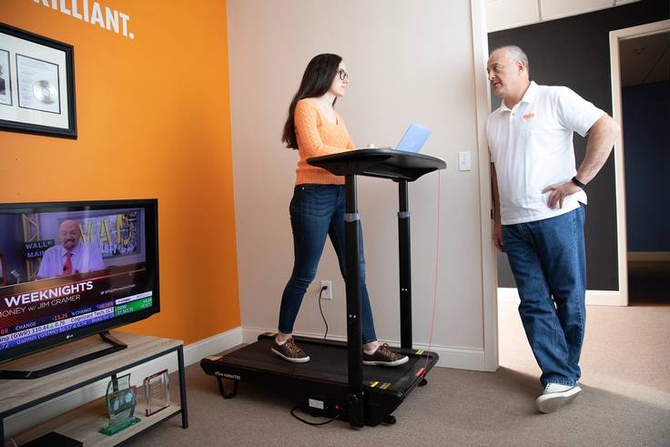 Intern Neny Lairet ’21 discussing the day’s tasks with Knoza Consulting COO Allen Kupetz while walking on the treadmill.