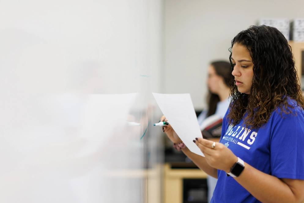 Adriane Griffith ’23 writing on the whiteboard in class.