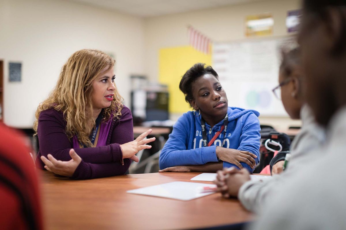 An elementary school teacher leads a group of students through a lesson.