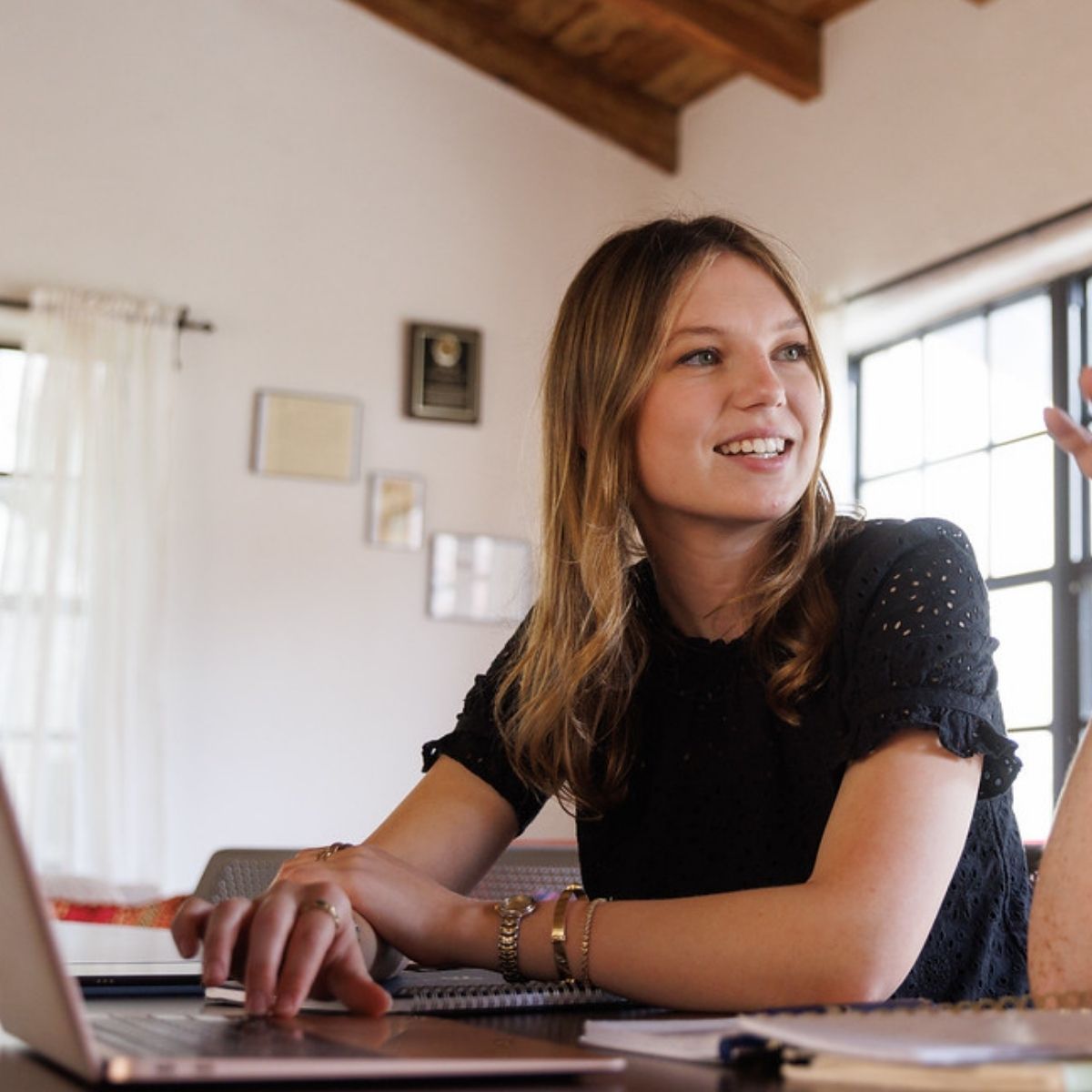 Capri in cap and graduation robe with cords and ribbons, outside on Rollins campus.