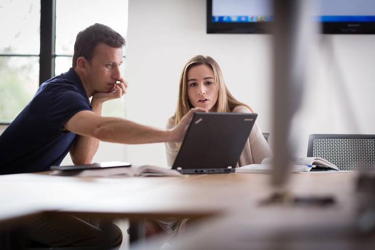 A professor advising a student in a Rollins classroom.