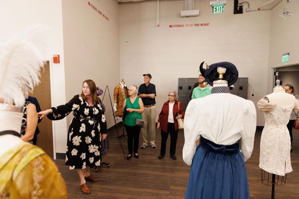 Visitors looking at mannequins dressed for production in the Costume & Design Studio