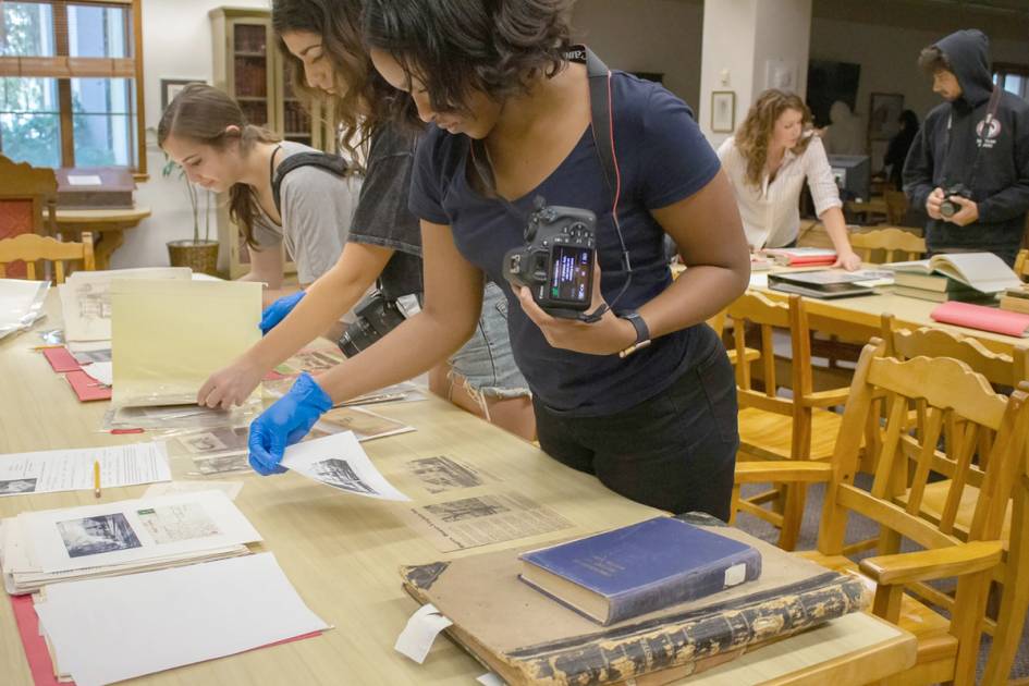 Students photograph archival content.